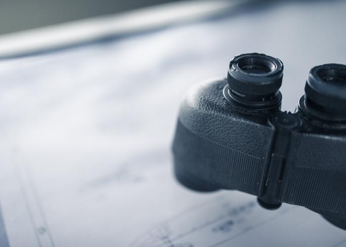 Binoculars resting on sheet of paper.