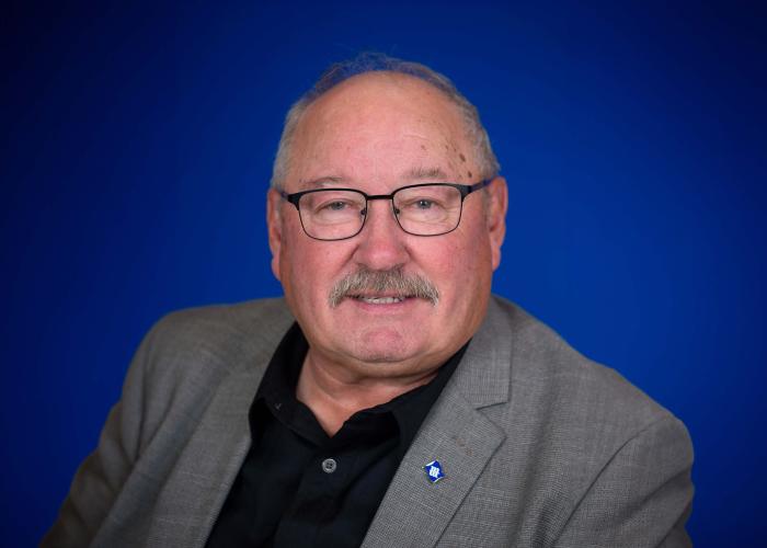 A photo of a man with a blue background