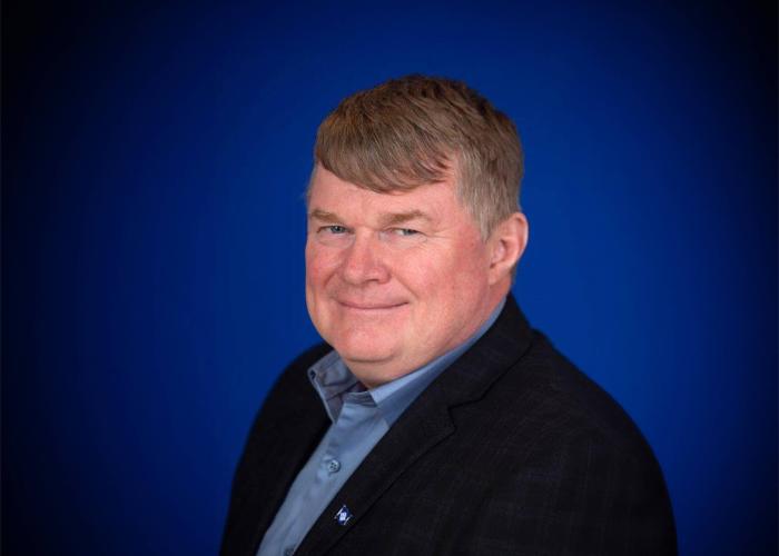 A photo of a man with a blue background