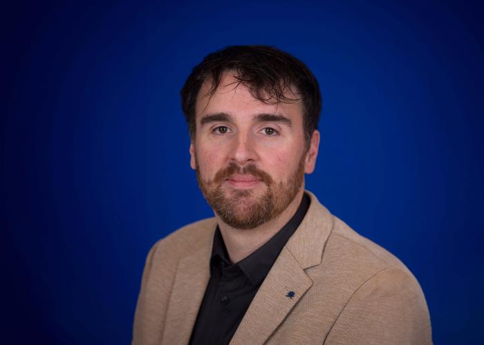 A photo of a man with a blue background