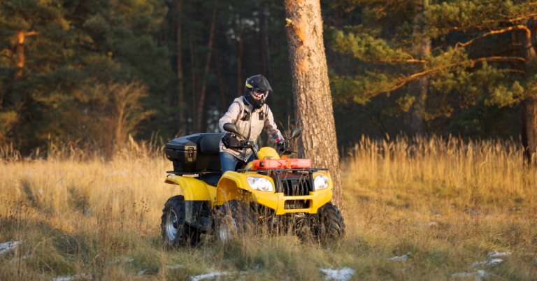 Person riding an ATV through a fall landscape