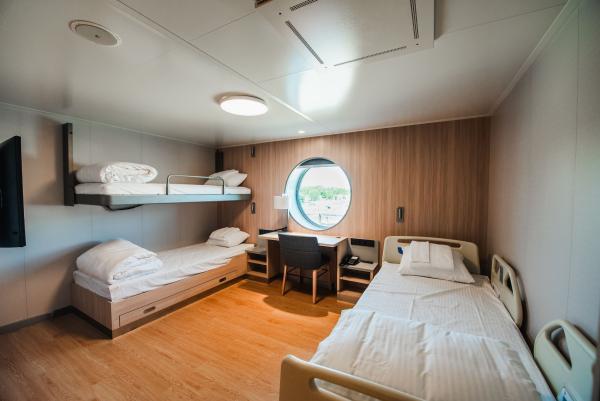 Cabin with one hospital-style bed and one set of bunk beds